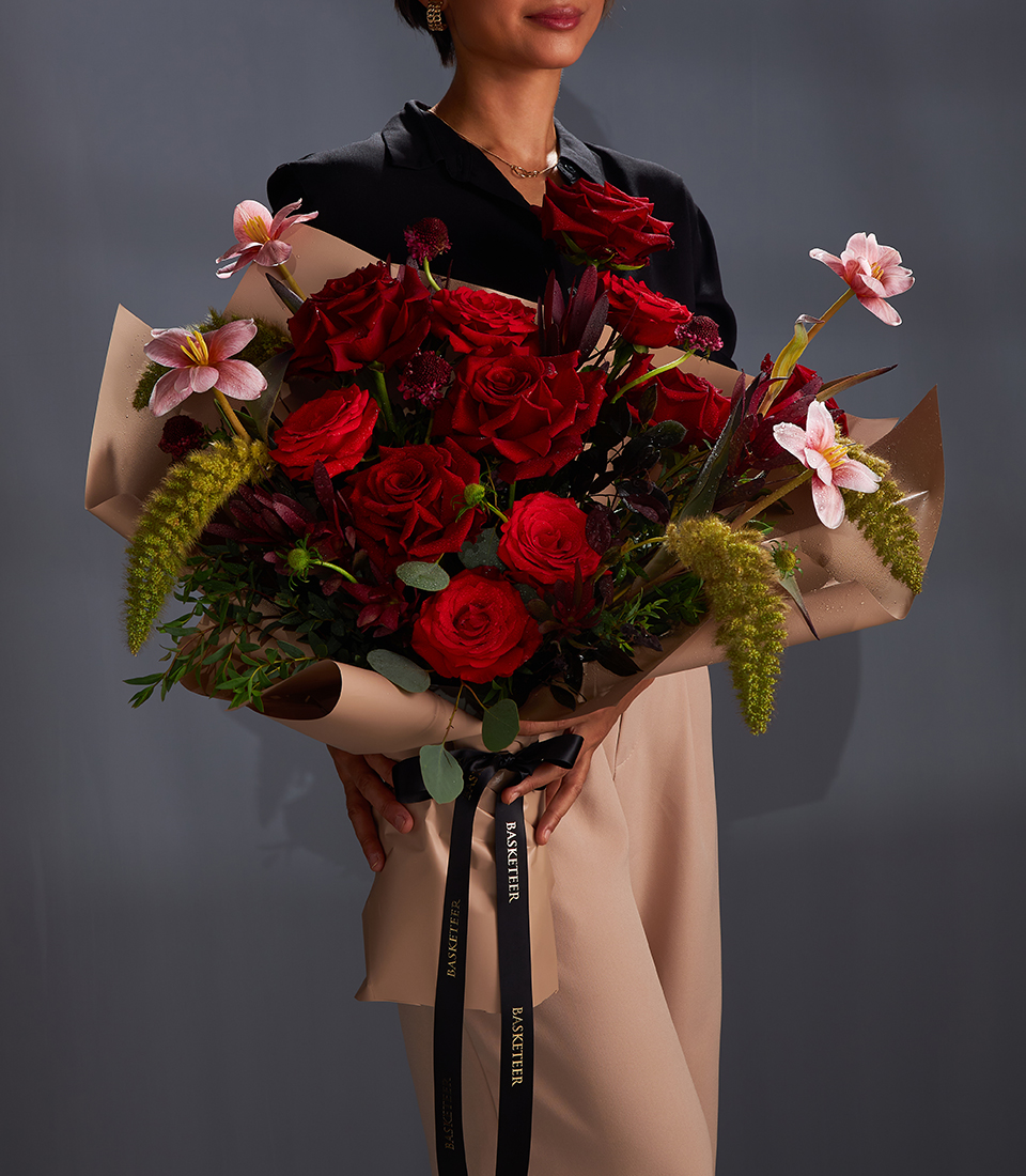 Deep red rose luxury bouquet with dramatic accents, wrapped in elegant tones for premium flower delivery in Bangkok.