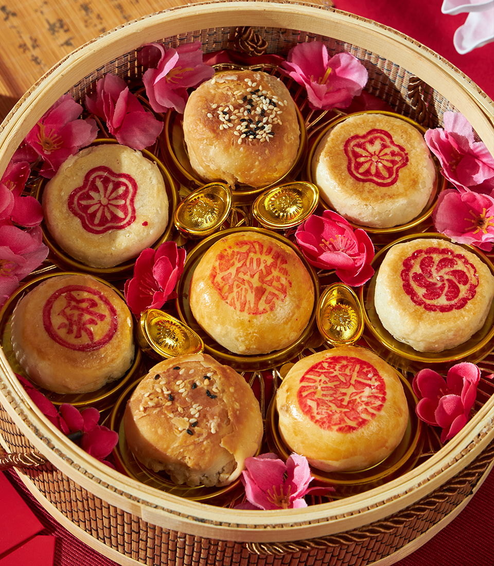 Traditional Chinese New Year mooncakes presented in a bamboo basket, reflecting Charlotte Bakery’s understated craftsmanship in Bangkok.
