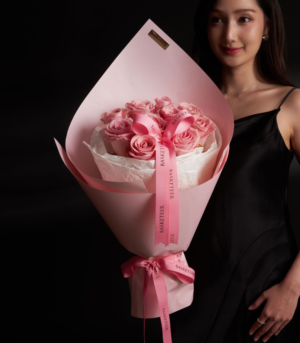 A vibrant deep pink rose bouquet for Valentine gift delivery in Bangkok SKU VLT26-2022lModel holding a luxury deep pink rose bouquet in pastel pink wrappinglClose-up of fresh deep pink roses in a premium Valentine arrangement with branded ribbonlSide view of a round pink rose bouquet with layered premium paper styling
