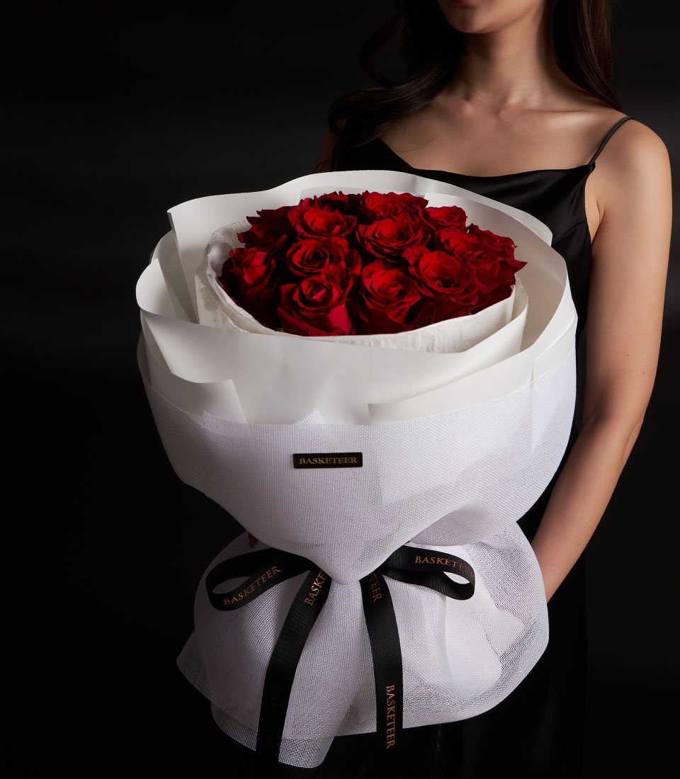 A grand red rose bouquet for Valentine gift delivery in Bangkok SKU VLT26-2018lModel holding a luxury red rose bouquet with white tulle and premium wrappinglClose-up of vibrant red roses in a grand Valentine arrangementlHigh-detail view of multiple red roses in a professional round bouquet