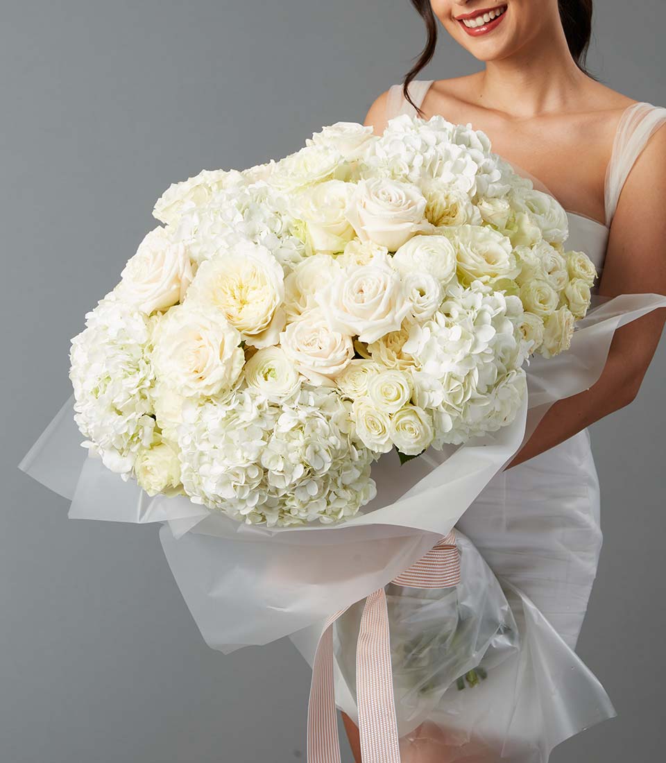 Large white rose and hydrangea bouquet in elegant luxury arrangement held by model Bangkok delivery