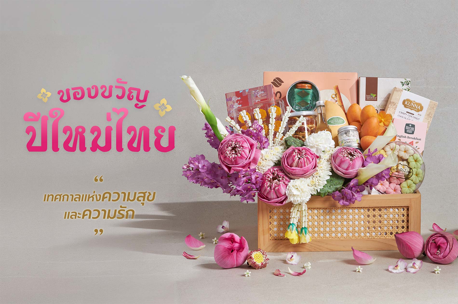 Songkran gift basket with lotus flowers, Thai desserts, fruits, and premium items in wooden basket